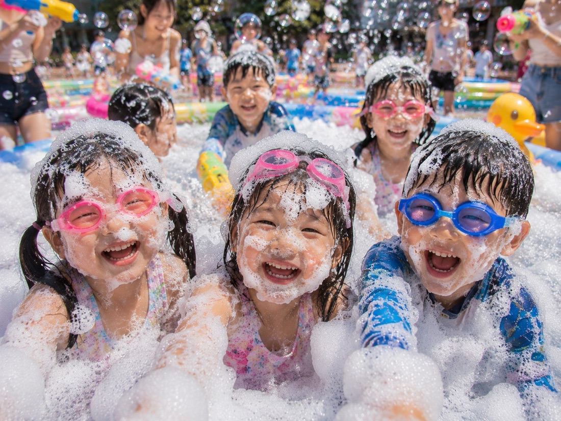 バブルプールで泡だらけになって笑う子どもたち